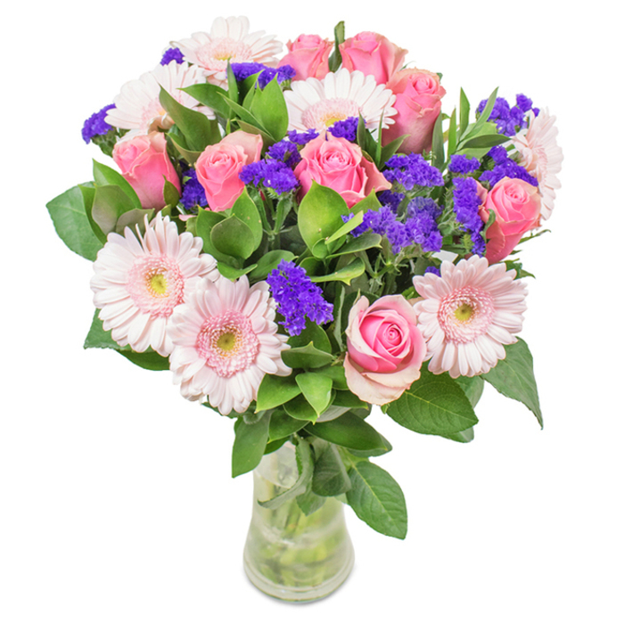 A gracefully arranged, vibrant bouquet sits in a clear cylindrical glass vase, its crisp design characteristic of Harold Park's refined floristry. Dominating the arrangement are 7 to 9 pink roses, their petals unfurling in the iconic spiral typical of florist-grade blooms-some just beginning to loosen from their tight embrace, others half-opened in romantic promise. Intermixed, about 5 to 7 pale pink gerbera daisies stand out with their generous, round heads and delicately ruffled petals, surrounding soft, almost translucent centers that catch the light streaming through the window, reminiscent of morning in Harold Park's gardens. Accents of vivid purple statice are carefully woven throughout, offering both textural intrigue and a splash of deeper hue, akin to blossoms found on a stroll through Central Park. Deep green foliage abounds at the base and between the blooms, lending volume and an aroma reminiscent of nearby open fields after a gentle rain. The slender vase displays the collection of stems and fresh water, reinforcing a sense of just-picked vitality so typical of a fresh Harold Park Florist delivery. An ideal gift for celebrations like birthdays, anniversaries, or simply to bring colour and joy to homes along Redden Court Road, this bouquet is infused with affection, cheer, and a distinctly local touch.